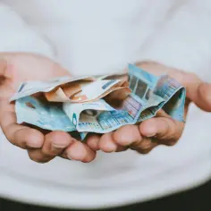 Dłonie trzymające banknoty euro. Pieniądze symbolizują wolność i możliwości, które często wiążą się z posiadaniem obywatelstwa.